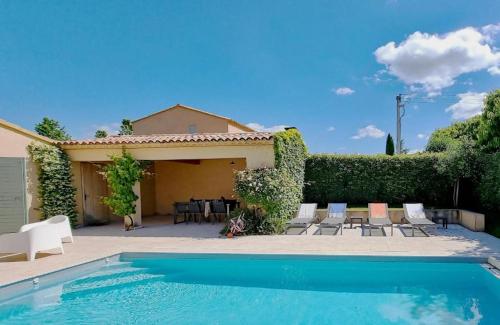 a house with a swimming pool and a table and chairs at Magique 16 - Luxe villa met privé zwembad voor 10p in Malaucène