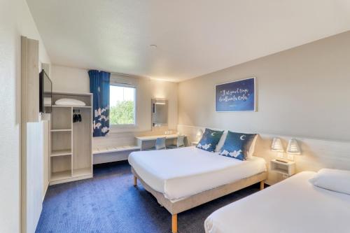 リオンにあるAce Hotel Riomのベッド2台とデスクが備わるホテルルームです。
