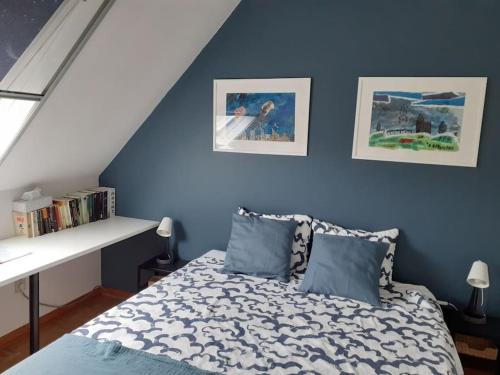 a bedroom with blue walls and a bed with pillows at Huis met 4 slaapkamers tussen Antwerpen en Brussel in Rumst