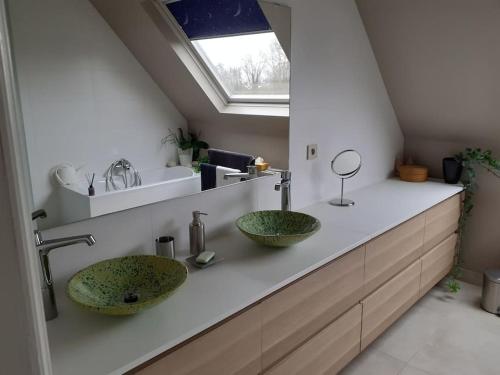 une salle de bain avec deux lavabos sur un comptoir avec une fenêtre dans l'établissement Huis met 4 slaapkamers tussen Antwerpen en Brussel, à Rumst