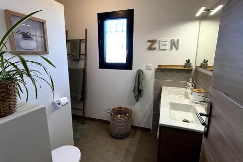 une salle de bain avec un lavabo et un miroir dans l'établissement Chez Céline - Belle maison climatisée piscine, à Carpentras