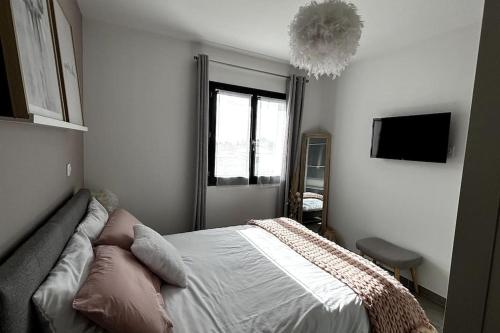 une chambre avec un lit, une fenêtre et un lustre dans l'établissement Chez Céline - Belle maison climatisée piscine, à Carpentras