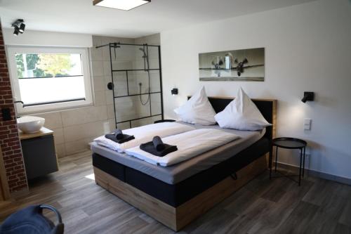 een slaapkamer met een groot bed en een douche bij Hotel Weilerhof in Dormagen