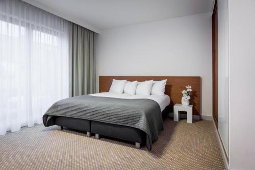 Un dormitorio con una cama grande y una ventana en Invite en Wroclaw