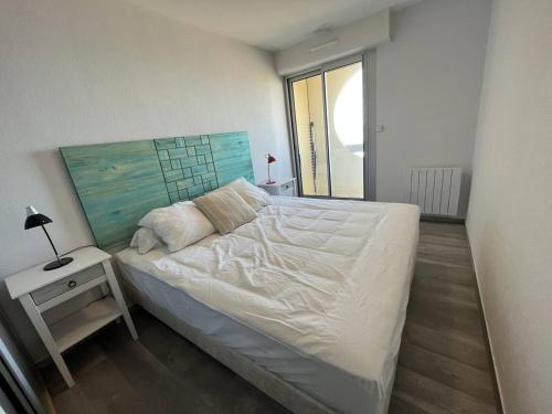 une chambre avec un lit et une table de chevet avec une lampe dans l'établissement Superbe T2 face mer à St Gilles avec Wifi, parking privé et accès direct à la plage - FR-1-324-233, à Saint-Gilles-Croix-de-Vie