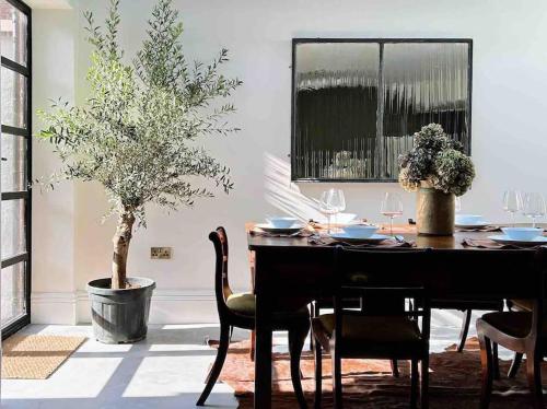 a dining room with a table with chairs and a tree at Luxury City Centre Townhouse - Sleeps 6 in Chester