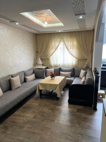 a living room with a couch and a table at Appartement Dar Bouazza Tamaris Casablanca Airport AquaParc Fibre Orange Wifi Parking Security in Dar Bouazza