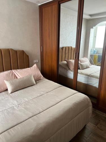 a bedroom with two beds and a large mirror at Appartement Dar Bouazza Tamaris Casablanca Airport AquaParc Fibre Orange Wifi Parking Security in Dar Bouazza