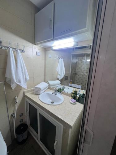 La salle de bains est pourvue d'un lavabo et d'un miroir. dans l'établissement Apparemment DarBouazza AquaParc FibreWifiParkingSecurity, à Dar Bouazza