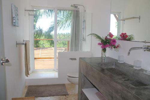 La salle de bains est pourvue d'un lavabo, de toilettes et d'une fenêtre. dans l'établissement Villa Mata De Mango, à El Limón