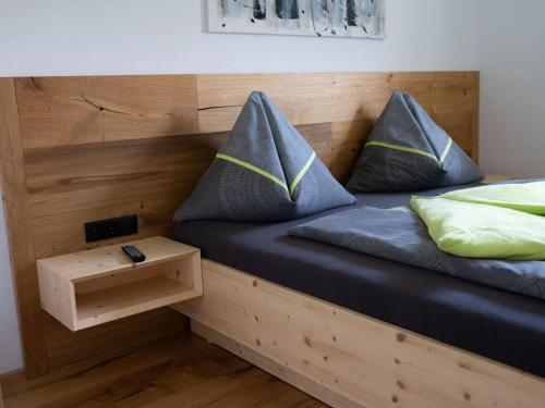 a bed with two pillows on it with a night stand at Pleasant holiday home near centre in Eben im Pongau