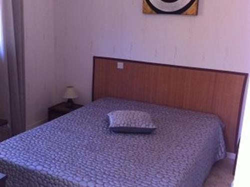 - un lit avec une couette bleue et un oreiller dans l'établissement Appartement F2 avec terrasse, parking et ascenseur - 2/4 pers - Amélie-les-Bains - FR-1-703-47, à Amélie-les-Bains-Palalda