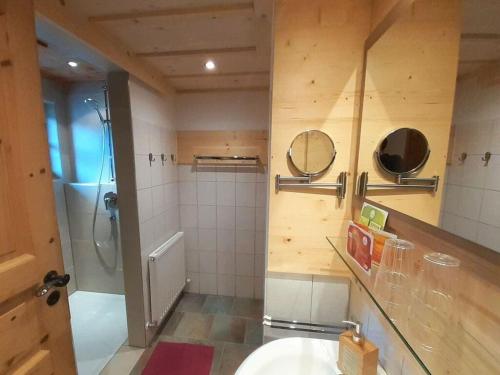 y baño con lavabo, ducha y espejo. en Spacious holiday home near ski-lift en Umhausen