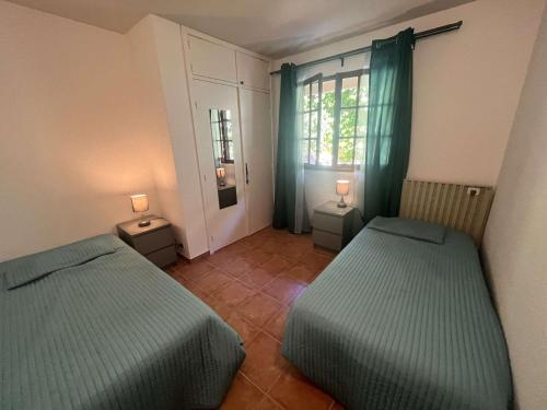une chambre avec deux lits et une fenêtre dans l'établissement Appartement 3P en rez-de-jardin avec piscine et parking, à 600m de la plage - Saint-Raphaël - FR-1-226A-151, à Saint-Raphaël