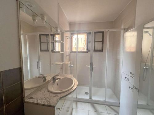 une salle de bain blanche avec un lavabo et une douche dans l'établissement Appartement 3P en rez-de-jardin avec piscine et parking, à 600m de la plage - Saint-Raphaël - FR-1-226A-151, à Saint-Raphaël