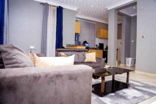 - un salon avec un canapé et une table dans l'établissement RK FURNISHED Apartments, à Kampala