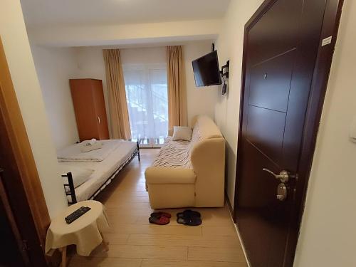 Zimmer mit einem Bett, einem Sofa und einem Fenster in der Unterkunft Apartman 1 in Vrnjačka Banja