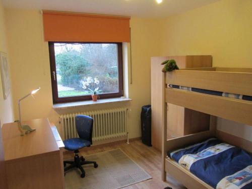 um quarto com uma secretária e um beliche em Nice holiday home near town centre em Gneversdorf