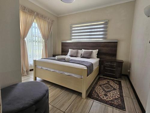 a bedroom with a large bed and a window at Emlanjeni Guest Lodge in White River