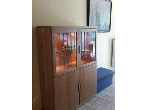 um armário de madeira com portas de vidro num quarto em Nice holiday home near town centre em Gneversdorf