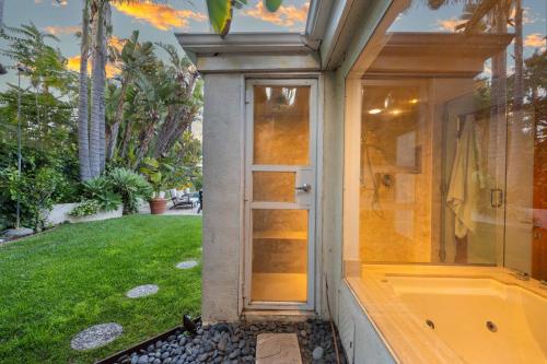 baño con bañera y puerta de cristal en Edwin by AvantStay Hollywood Hills Luxury Pool, en Los Ángeles