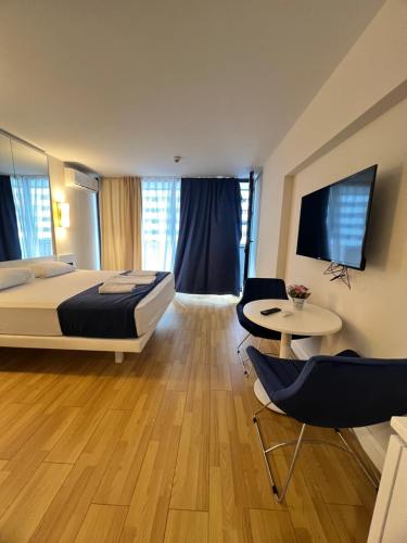 ein Hotelzimmer mit einem Bett, einem Tisch und Stühlen in der Unterkunft Orbi city Aparthotel in Batumi