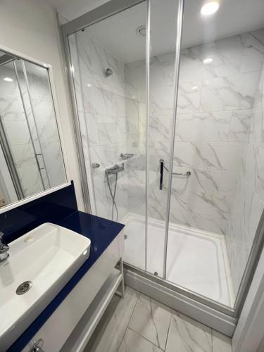 ein Bad mit einer Dusche und einem Waschbecken in der Unterkunft Orbi city Aparthotel in Batumi