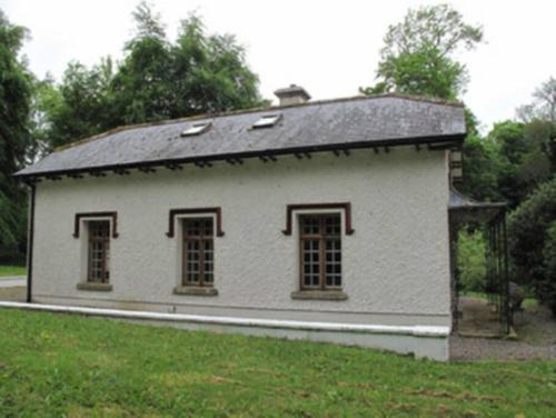 a white building with windows and a roof at The Gatelodge, Hilton Park in Monaghan