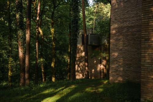 a brick building next to a group of trees at Forest Hotel in Kraków