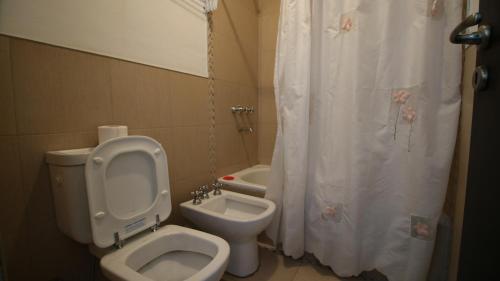 a bathroom with a toilet and a shower curtain at Departamentos Córdoba Vaes in Cordoba