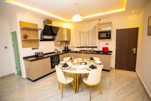 a kitchen with a table and chairs in a room at The Pearl - Lincoln - 2nd floor in Kumasi
