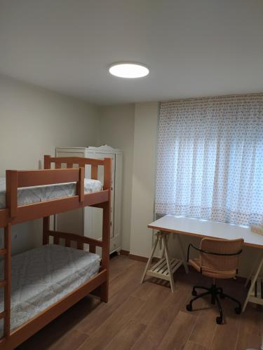 a room with bunk beds and a desk and a table at Vacacional muelle alto A Guarda in A Guarda