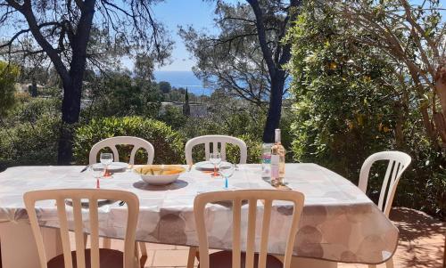 une table avec quatre chaises et un tissu de table blanc dans l'établissement VILLA ALPASA - Boulouris AIGUEBONNE, Villa vue mer dans domaine 5 min à pied de la plage, à Saint-Raphaël