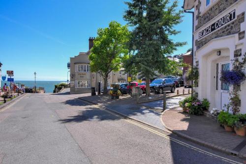 a street in a town with cars parked on the street at Sea Haven in Seaton