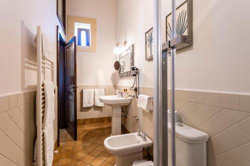 łazienka z toaletą i umywalką w obiekcie Relais Torre Marabino w mieście Ispica