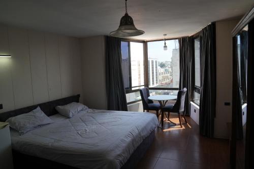Schlafzimmer mit einem Bett und einem Tisch mit Stühlen in der Unterkunft Omayah hotel irbid in Irbid