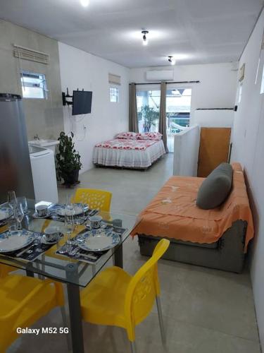 um quarto com uma mesa e uma cama e uma mesa e cadeiras em Studio com varanda - Melhor localização do Arruda no Recife