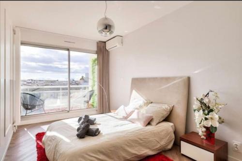 une chambre avec un lit avec un ours en peluche dessus dans l'établissement l'élégant T3Nîmes Parking-centre ville, à Nîmes