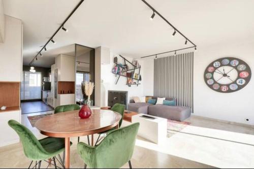 - un salon avec une table en bois et des chaises vertes dans l'établissement l'élégant T3Nîmes Parking-centre ville, à Nîmes