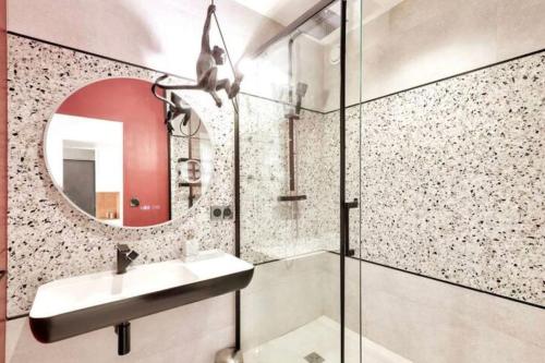 une salle de bain avec un lavabo et un miroir dans l'établissement l'élégant T3Nîmes Parking-centre ville, à Nîmes