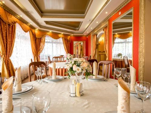 a dining room with a table with flowers on it at Hotel&SPA Pysanka, Готель Писанка, 3 сауни та джакузі - індивідуальний відпочинок у СПА in Lviv