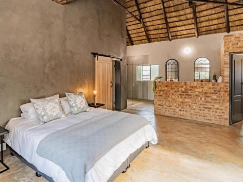 um quarto com uma cama e uma parede de tijolos em Featherwood Farm & Nyala Lodge em Rayton