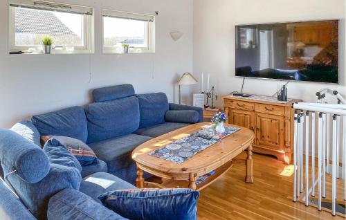 雪平斯维克5 Bedroom Stunning Home In Köpingsvik的客厅里有一张蓝色的沙发和一张桌子