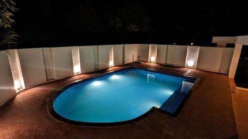 a swimming pool at night with lights on it at Luxury Villa with Swimming Pool in Jaipur