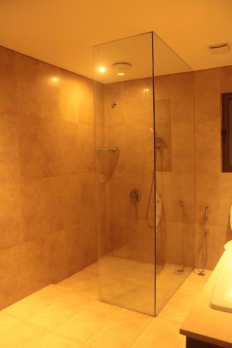 a bathroom with a glass shower with a toilet at Niva Stays Riverside 1 in Kharadi