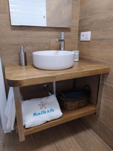 a bathroom sink on a wooden table with a basket at Vacacional muelle alto A Guarda in A Guarda
