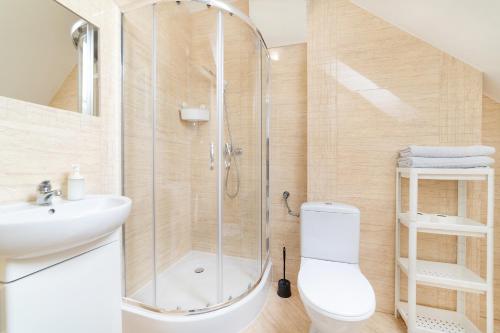 a bathroom with a shower and a toilet and a sink at Pokoje Gościnne Dominika in Jastarnia