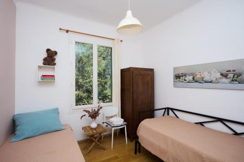 1 dormitorio con 2 camas y ventana en Appartements avec jardin dans Villa Rocaille, en Cassis
