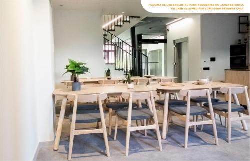 a dining room with a wooden table and chairs at Coliving Compostela in Santiago de Compostela