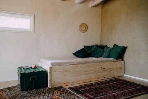 a bedroom with a wooden bed with green pillows at Eco-friendly Welness Tiny House in Liglet in Liglet